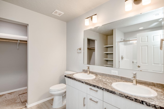 full bathroom with visible vents, a shower stall, toilet, and a sink