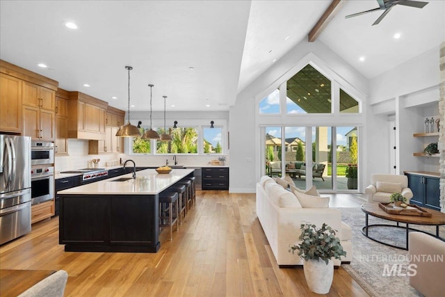 8848 Overunder Ln, Middleton, ID 83644 - kitchen with a sink, appliances with stainless steel finishes, light countertops, light wood-type flooring, and an island with sink