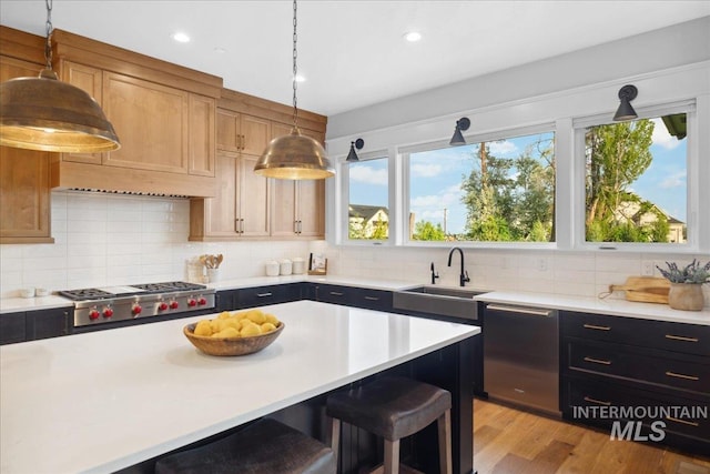 8848 Overunder Ln, Middleton, ID 83644 - kitchen featuring appliances with stainless steel finishes, a sink, light countertops, hanging light fixtures, and recessed lighting