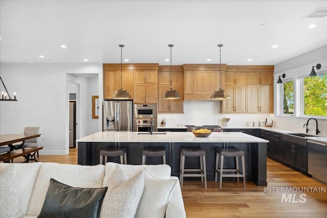 8848 Overunder Ln, Middleton, ID 83644 - kitchen with stainless steel appliances, a sink, open floor plan, light countertops, and a spacious island