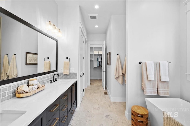 8848 Overunder Ln, Middleton, ID 83644 - bathroom with double vanity, a freestanding bath, recessed lighting, a walk in closet, and baseboards