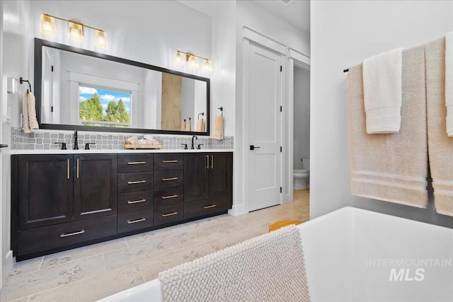 8848 Overunder Ln, Middleton, ID 83644 - bathroom with double vanity, tasteful backsplash, toilet, and a tub