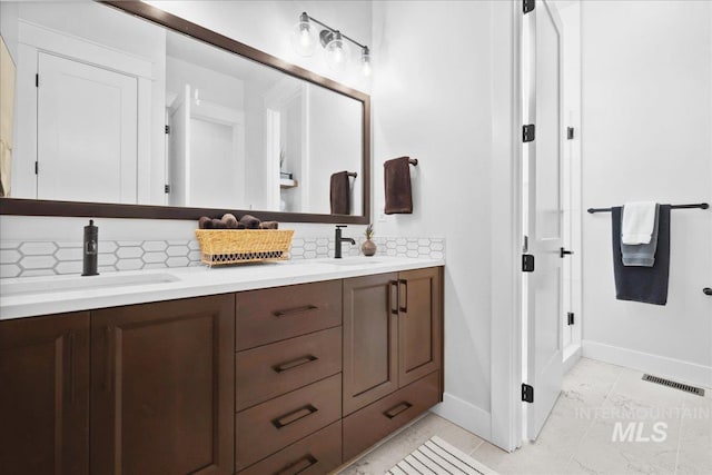 8848 Overunder Ln, Middleton, ID 83644 - bathroom featuring double vanity, baseboards, tasteful backsplash, and tile patterned flooring