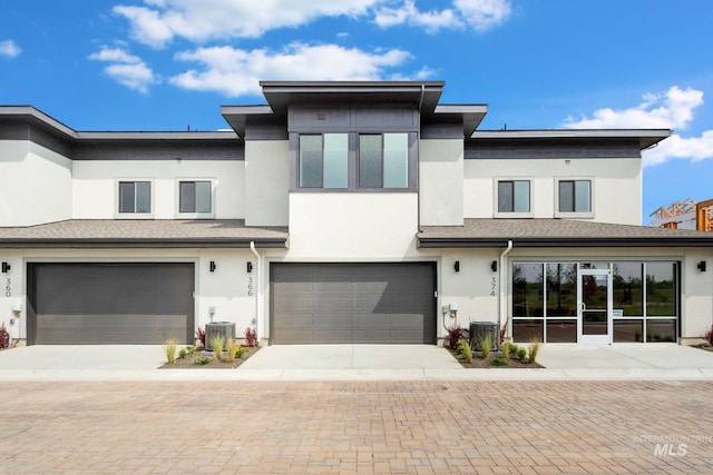 view of front of house featuring central AC unit and a garage