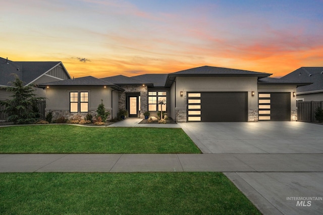 view of front of home featuring a front yard, stone siding, an attached garage, and stucco siding