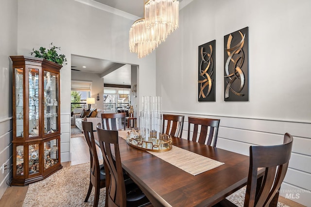 dining room with crown molding, a notable chandelier, and wood finished floors