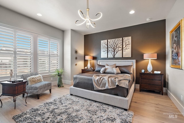 bedroom with light wood-style floors, baseboards, a notable chandelier, and recessed lighting