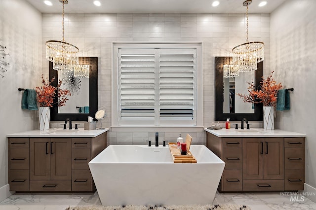 bathroom featuring a chandelier, marble finish floor, and a sink