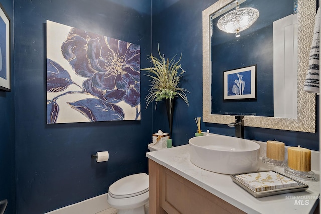 bathroom featuring vanity, toilet, and baseboards