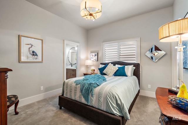 carpeted bedroom featuring a chandelier, baseboards, and ensuite bathroom