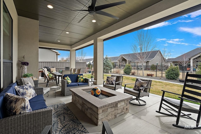 view of patio with an outdoor living space with a fire pit, a residential view, and fence