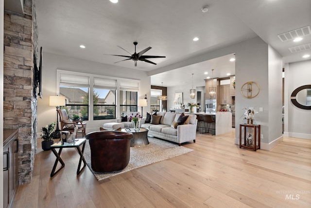 living room with light wood finished floors, visible vents, a ceiling fan, and recessed lighting