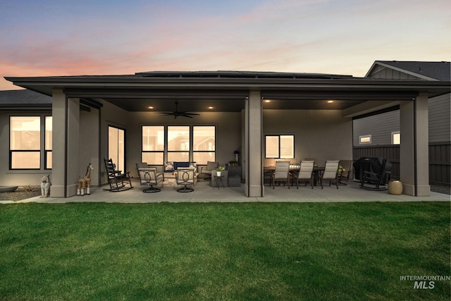 back of house featuring stucco siding, a patio area, a lawn, and ceiling fan