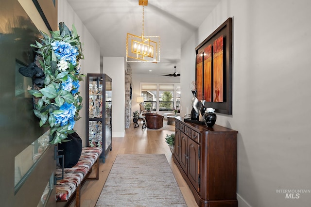 entrance foyer featuring baseboards, light wood-type flooring, and an inviting chandelier