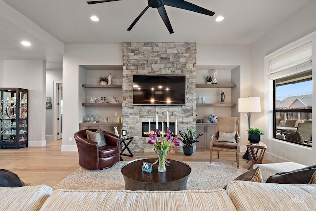 living area featuring recessed lighting, a fireplace, wood finished floors, and built in features