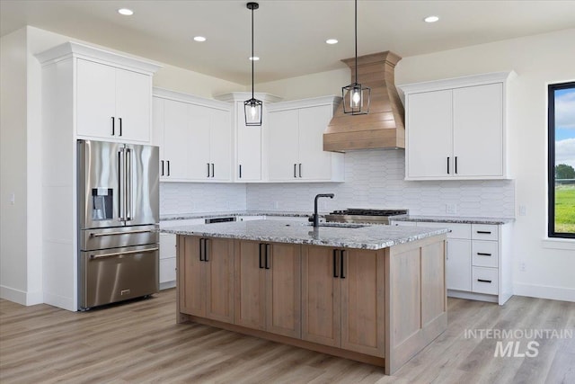 4069N 2200 2200 E E, Filer, ID 83328 - kitchen featuring stainless steel fridge with ice dispenser, light wood finished floors, an island with sink, light stone counters, and backsplash
