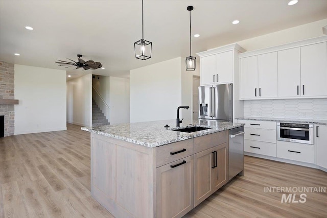 4069N 2200 2200 E E, Filer, ID 83328 - kitchen with stainless steel appliances, a sink, a center island with sink, open floor plan, and light wood-type flooring