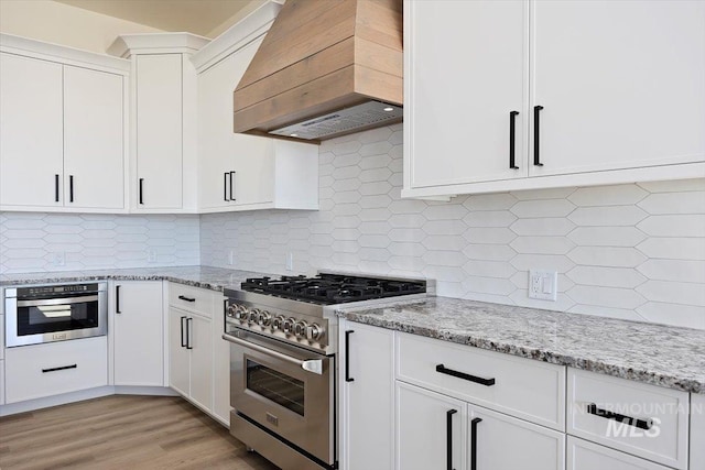 4069N 2200 2200 E E, Filer, ID 83328 - kitchen featuring appliances with stainless steel finishes, custom exhaust hood, white cabinetry, and light stone counters