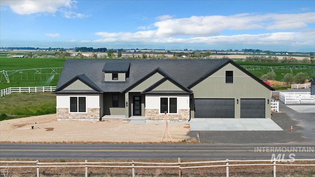 4069N 2200 2200 E E, Filer, ID 83328 - view of front of home with stone siding, concrete driveway, a garage, and a view of rural / pastoral area