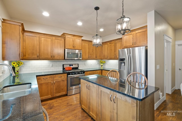 9462 W Whitecrest, Star, ID 83669 - kitchen with appliances with stainless steel finishes, a kitchen island, decorative light fixtures, dark stone counters, and recessed lighting
