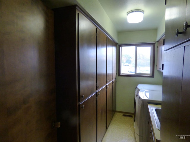 laundry area with washing machine and dryer and cabinets