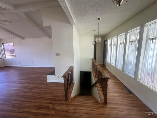 stairs featuring wood-type flooring, a wealth of natural light, and a chandelier