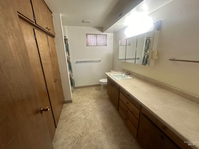 bathroom with concrete floors, vanity, and toilet