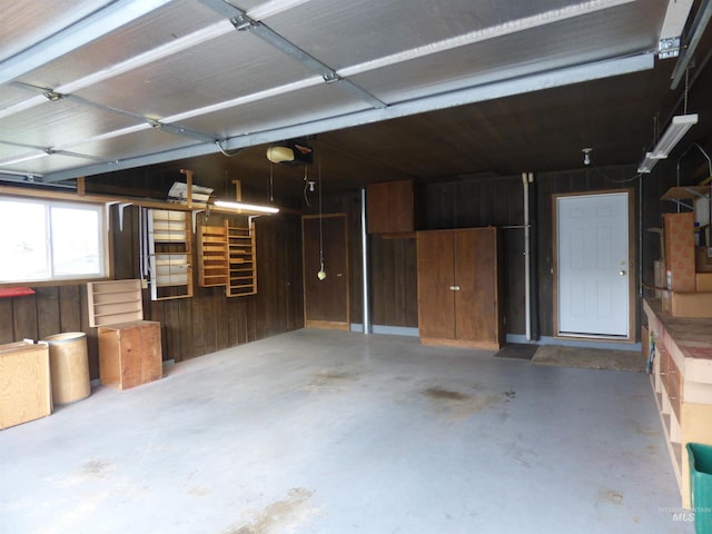 garage with wooden walls and a garage door opener