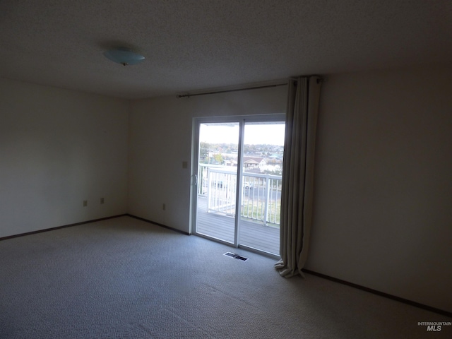 unfurnished room featuring a textured ceiling and carpet floors