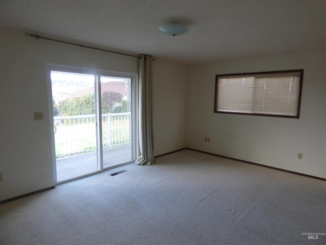 carpeted spare room featuring a textured ceiling