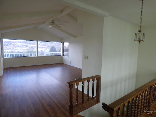 empty room featuring lofted ceiling with beams, dark wood-type flooring, and ceiling fan with notable chandelier