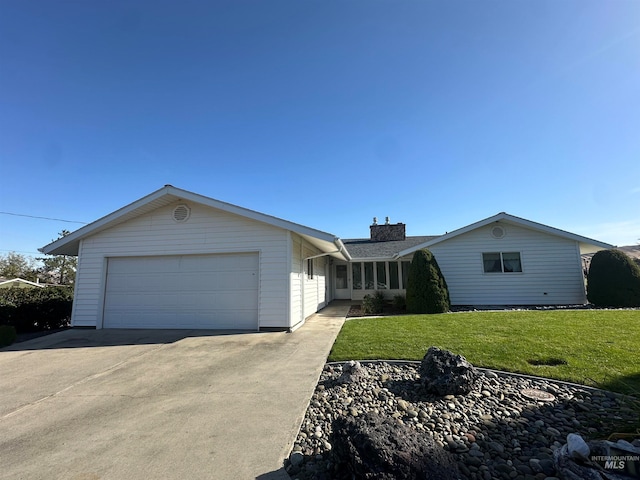 ranch-style home featuring a garage and a front lawn