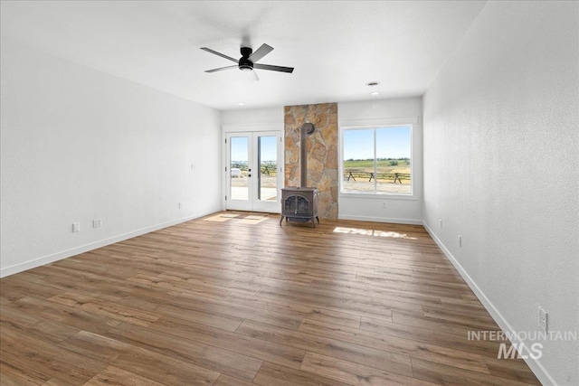 1006 Hill Rd, Homedale, ID 83628 - unfurnished living room with a wood stove, ceiling fan, wood finished floors, and a textured wall