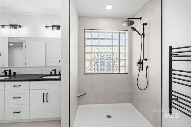 1006 Hill Rd, Homedale, ID 83628 - full bathroom with radiator heating unit, tiled shower, a towel warmer, and double vanity