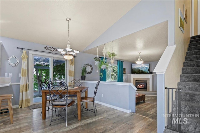 583 E Willowridge Ct, Kuna, ID 83634 - dining room featuring wood finished floors, a chandelier, stairway, lofted ceiling, and baseboards