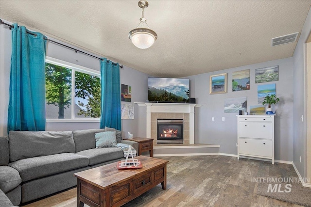 583 E Willowridge Ct, Kuna, ID 83634 - living room with wood finished floors, a fireplace, a textured ceiling, and baseboards