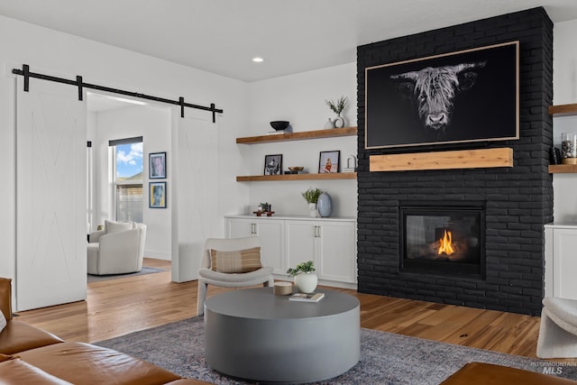 13684 N Sage Grouse Pl, Boise, ID 83714 - living room featuring a fireplace, a barn door, recessed lighting, and wood finished floors
