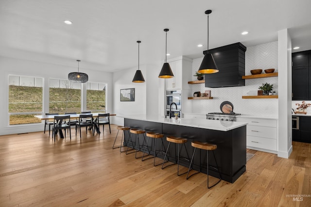 13684 N Sage Grouse Pl, Boise, ID 83714 - kitchen with backsplash, light countertops, a kitchen breakfast bar, light wood-style floors, and open shelves
