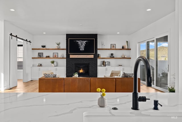13684 N Sage Grouse Pl, Boise, ID 83714 - living area featuring recessed lighting, a fireplace, light wood-style floors, and a barn door