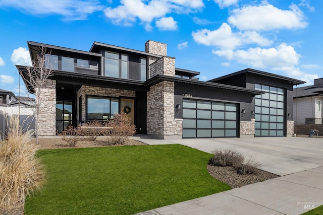 view of front of house featuring a front yard, an attached garage, a chimney, concrete driveway, and stone siding