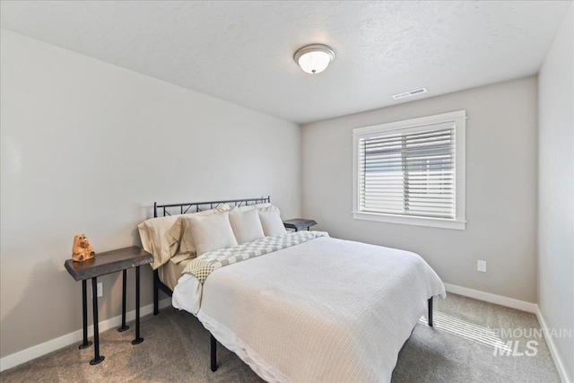 carpeted bedroom featuring baseboards and visible vents