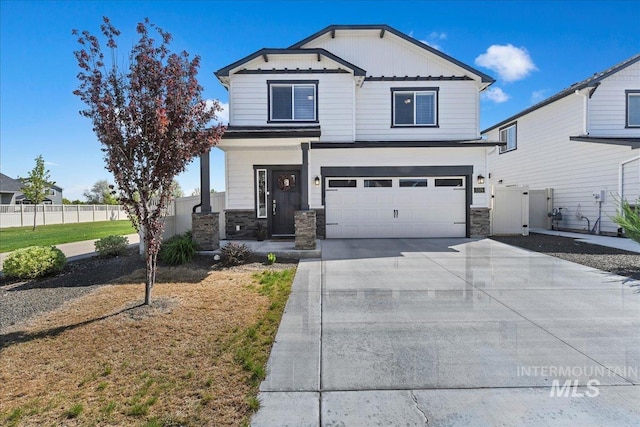 view of front facade featuring fence, an attached garage, driveway, and stone siding