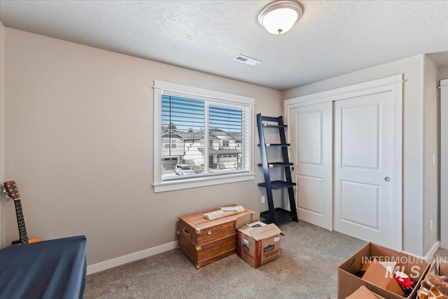 misc room featuring baseboards, visible vents, and carpet