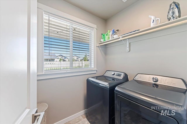 laundry room with laundry area, baseboards, and separate washer and dryer