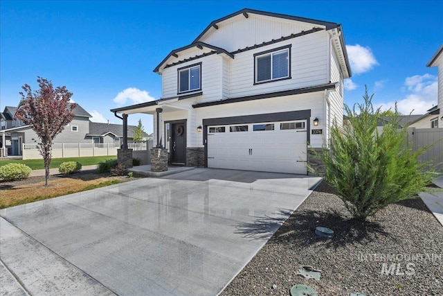 view of front facade with an attached garage, fence, driveway, and stone siding