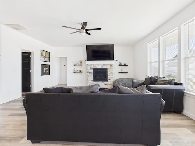 2420 Great Basin Way, Burley, ID 83318 - living room featuring ceiling fan, light wood finished floors, baseboards, and a stone fireplace