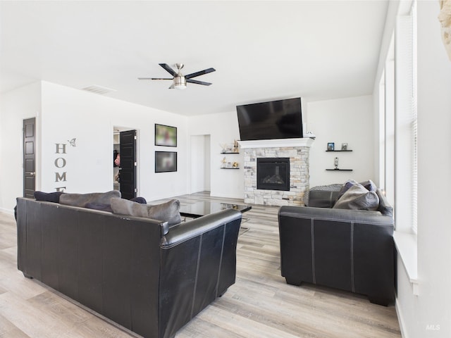 2420 Great Basin Way, Burley, ID 83318 - living room featuring a ceiling fan, a stone fireplace, and light wood finished floors