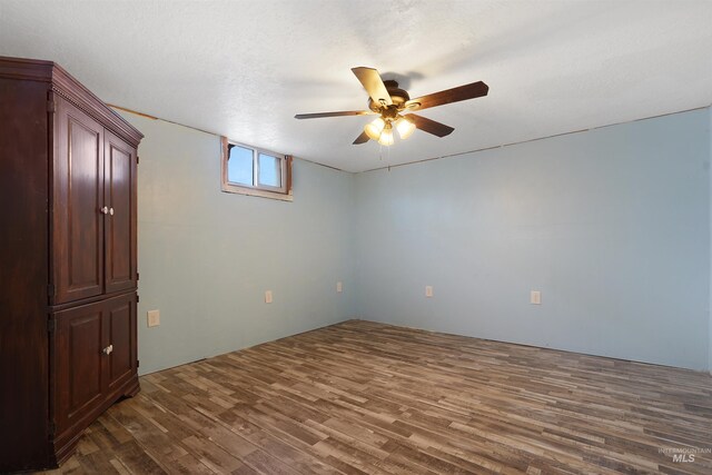 empty room featuring dark hardwood / wood-style flooring, ceiling fan, and a textured ceiling