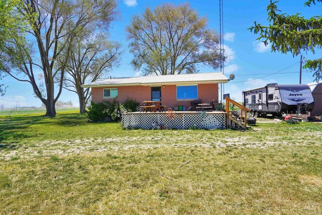 rear view of property with a deck and a lawn