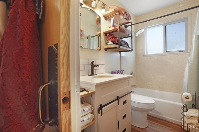 full bathroom featuring shower / bath combo with shower curtain, wood-type flooring, tasteful backsplash, vanity, and toilet